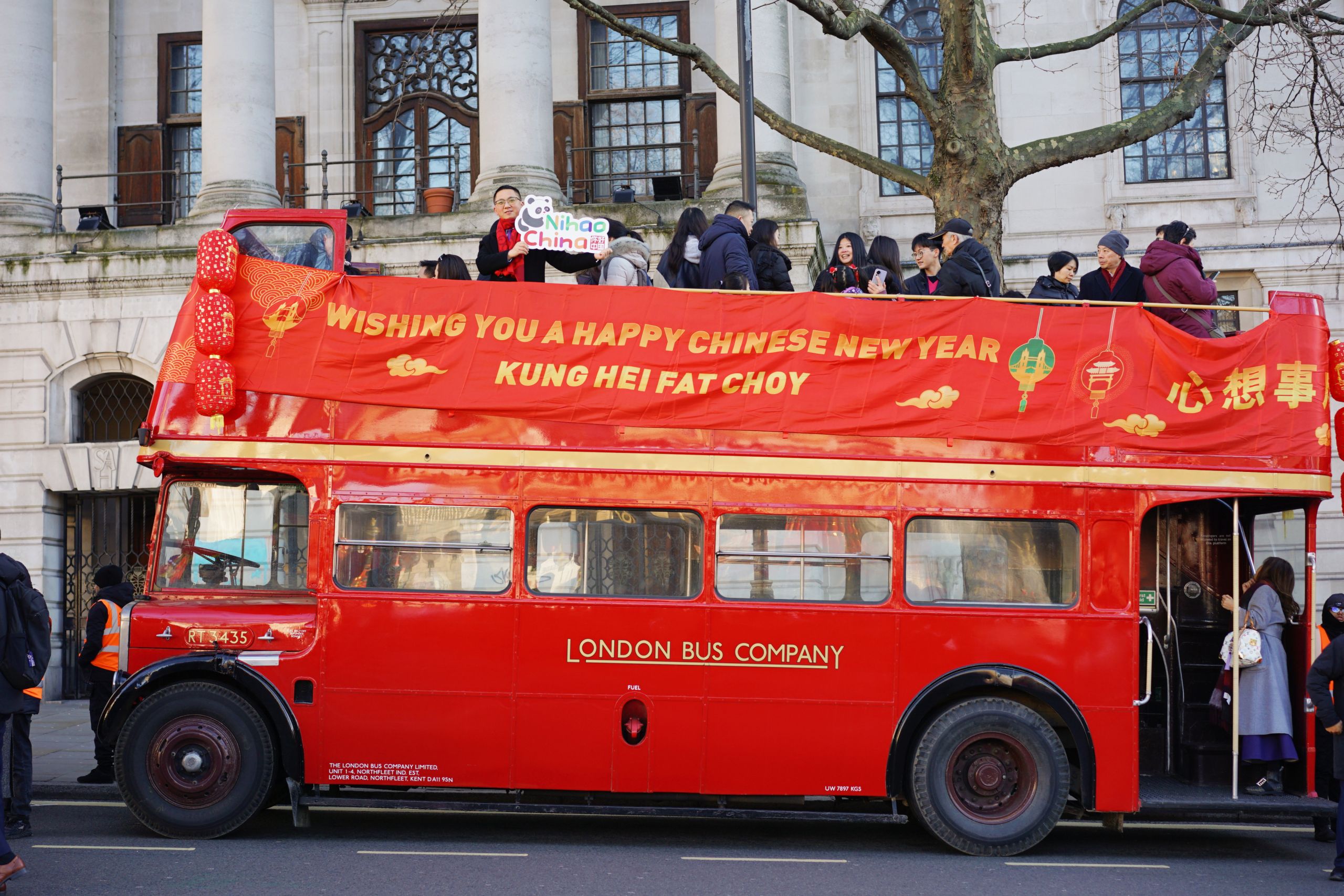 A red bus with a banner on top AI-generated content may be incorrect.